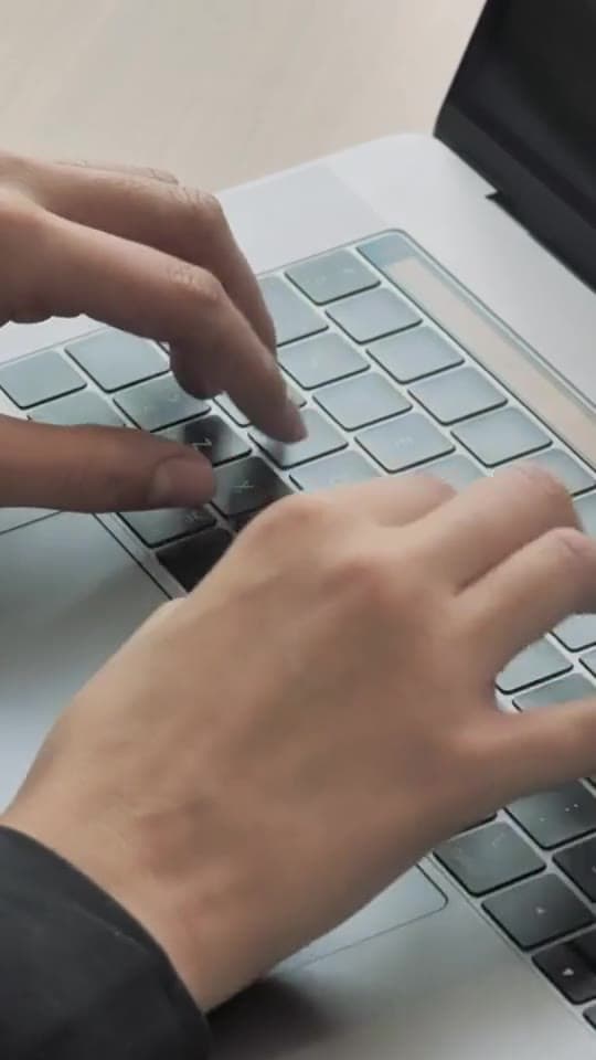Illustrative stock film of hands typing on a laptop